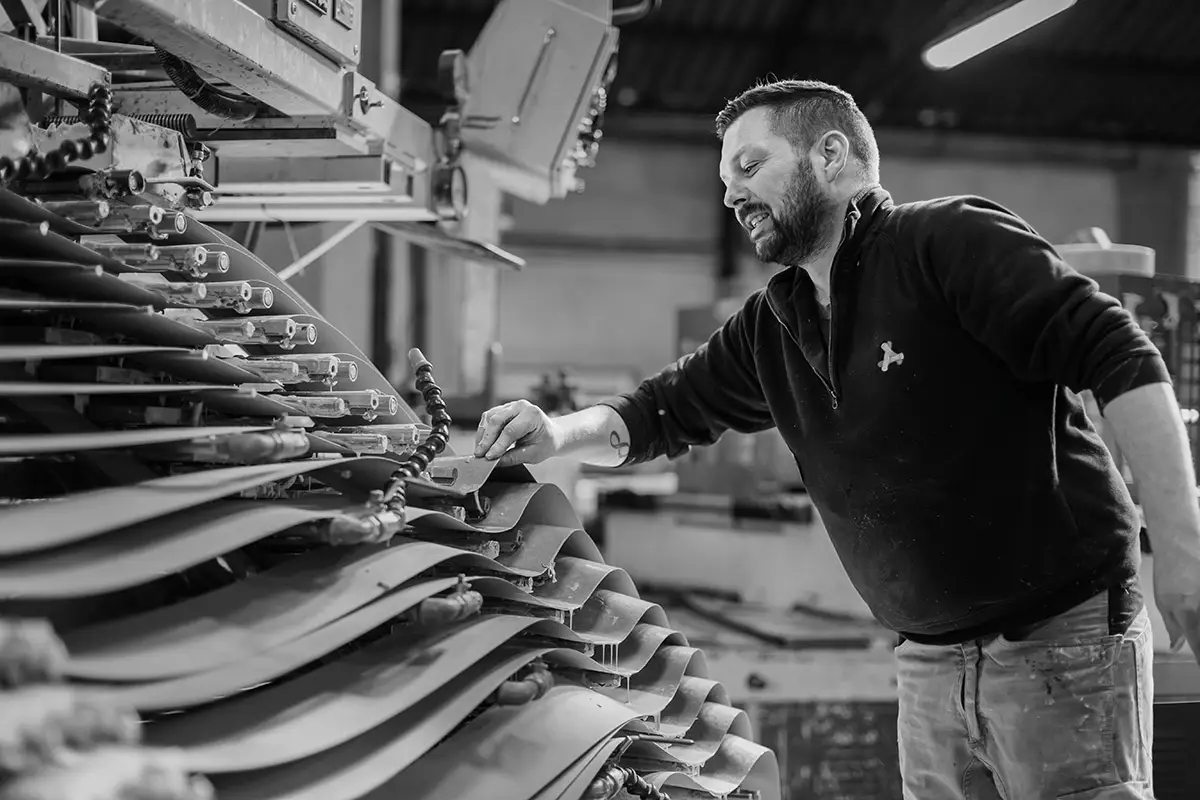 Collaborateur EM2 réglant les bandes de sa spiraleuse pour la fabrication de tubes carton